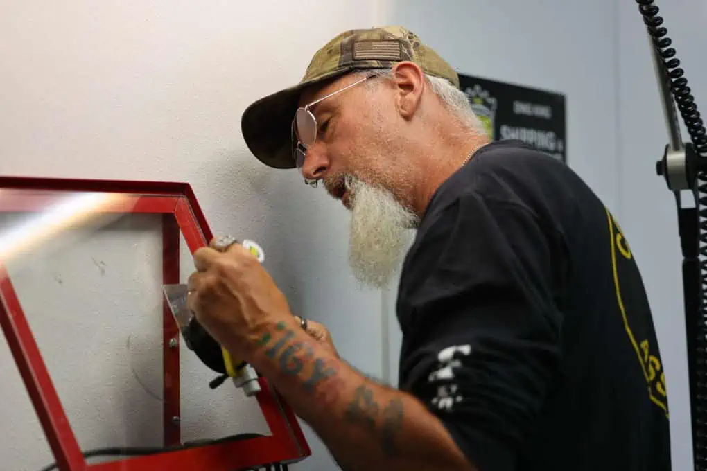 A bearded man is engaged in Windshield Repair training.