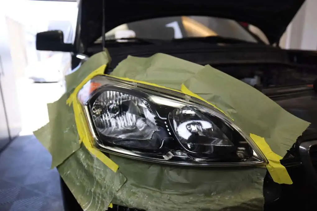 A car's headlight receives headlight renewal.