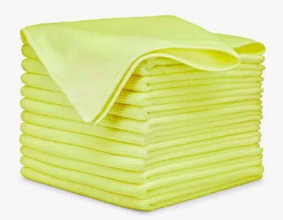 A stack of yellow towels used in auto detailing on a white background.